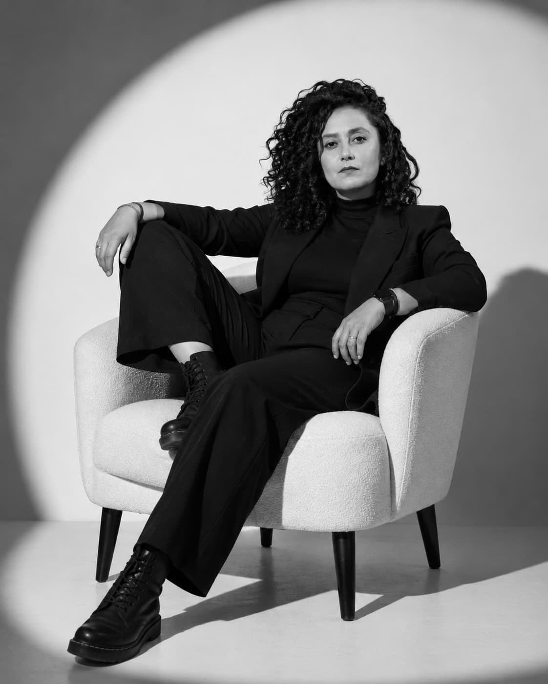 Florencia Lovera-Hampshire sentada en un sillón blanco bajo un círculo de luz.